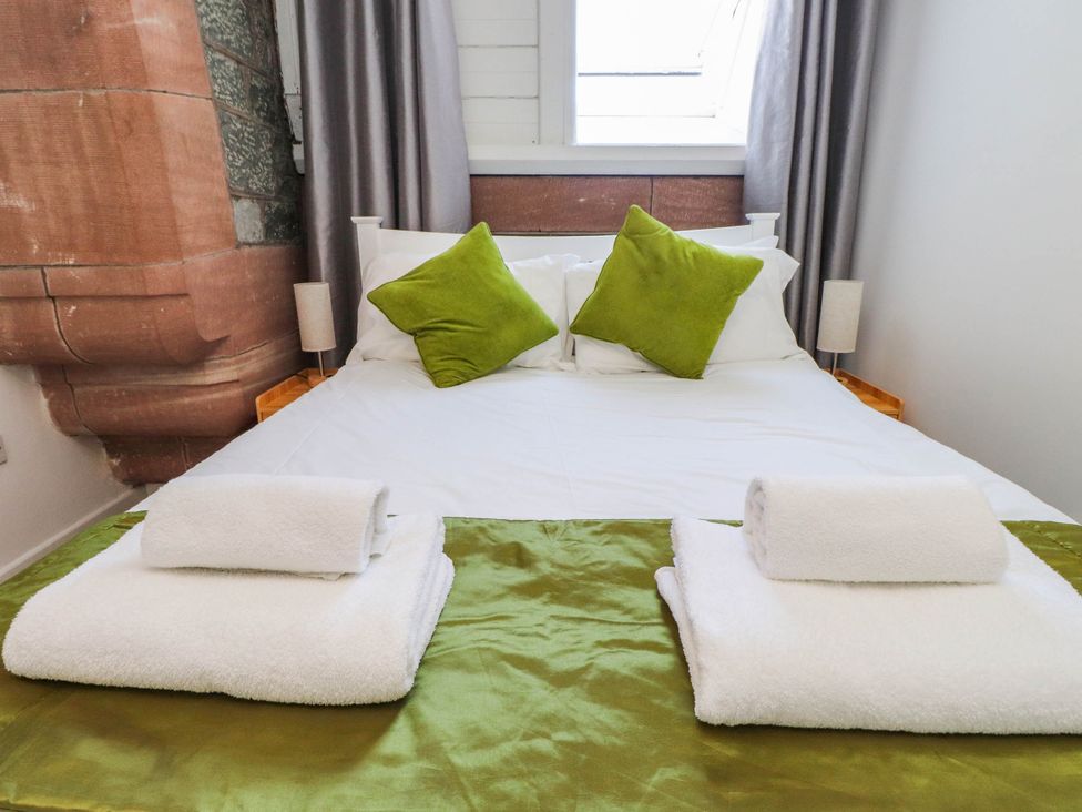 A bedroom with a bed and pillows at Flat 16 Criccieth