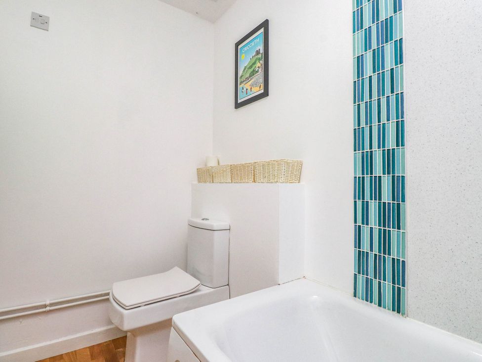 A bathroom featuring a toilet and bathtub at Flat 16 in Criccieth