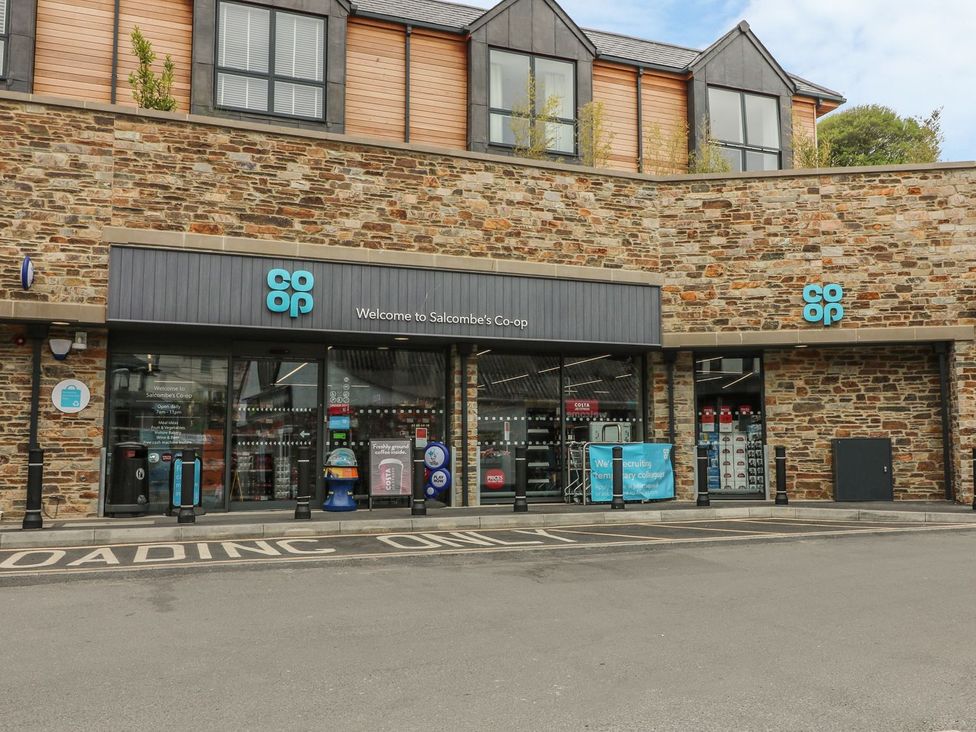 A store entrance with signage at Salcombe's Co-op in Salcombe