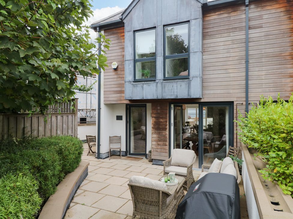 An outdoor patio with seating and grill at Beachstone in Salcombe