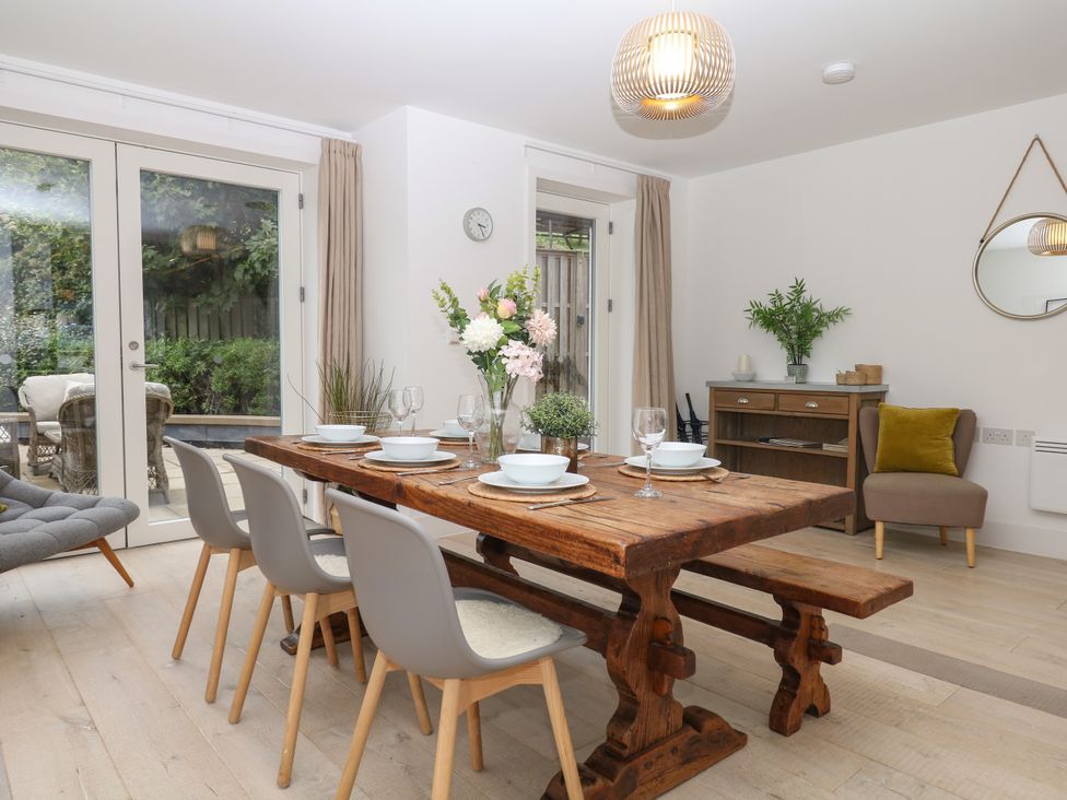 A dining room with a wooden table and chairs at Beachstone in Salcombe