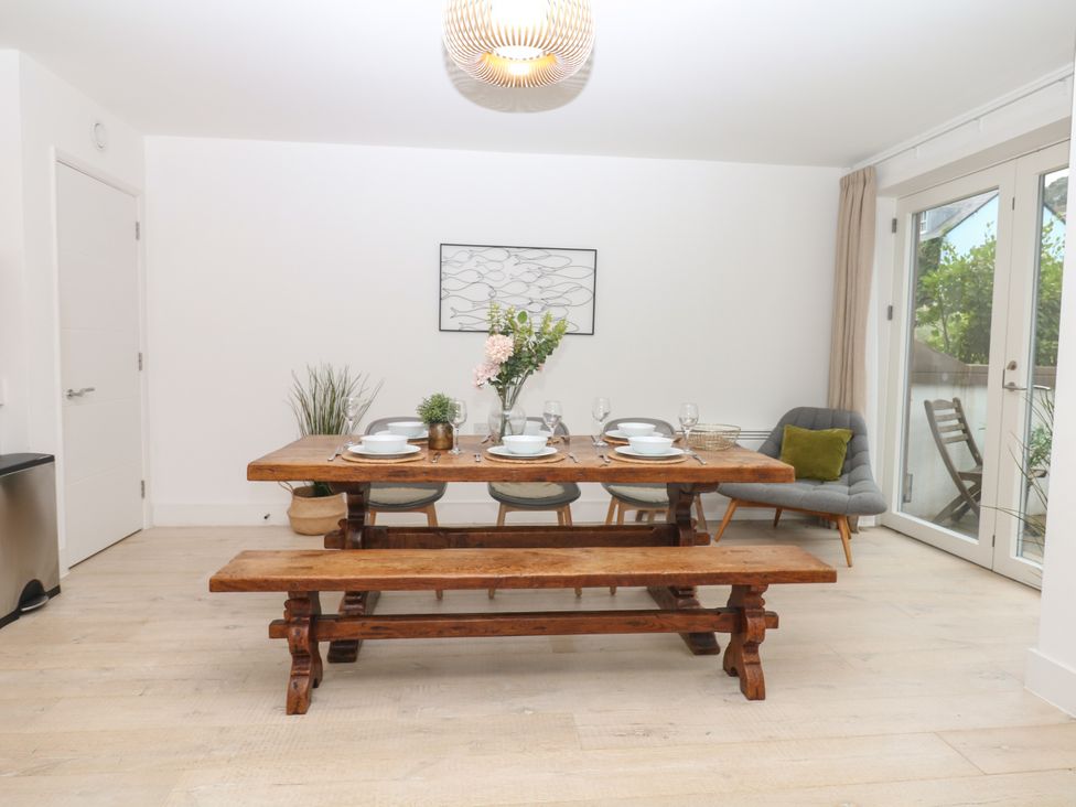 A dining room with a wooden table and chairs at Beachstone in Salcombe