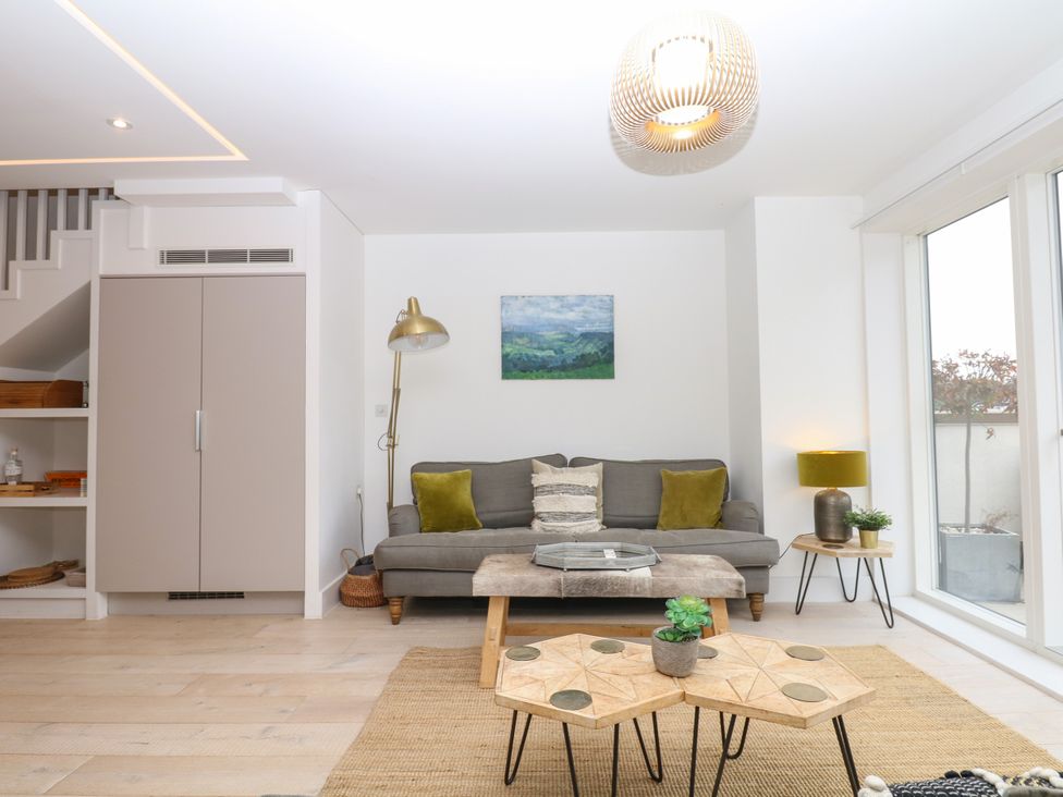 A living room with a sofa and a table at Beachstone in Salcombe