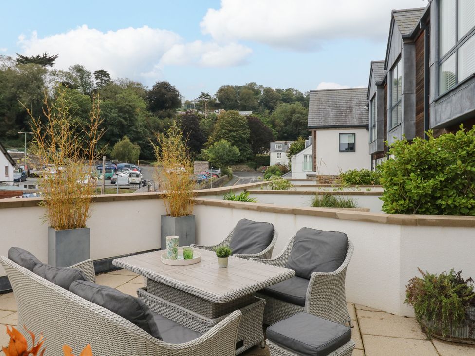 A patio area with outdoor furniture and planters at Beachstone in Salcombe