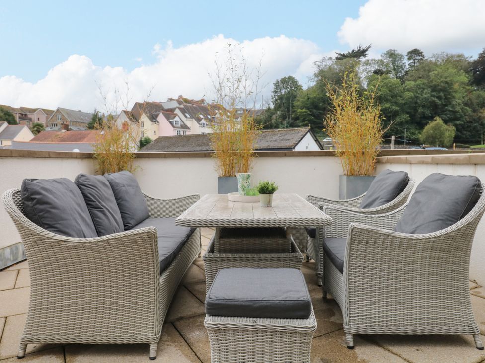 A seating area with a table and cushions at Beachstone in Salcombe