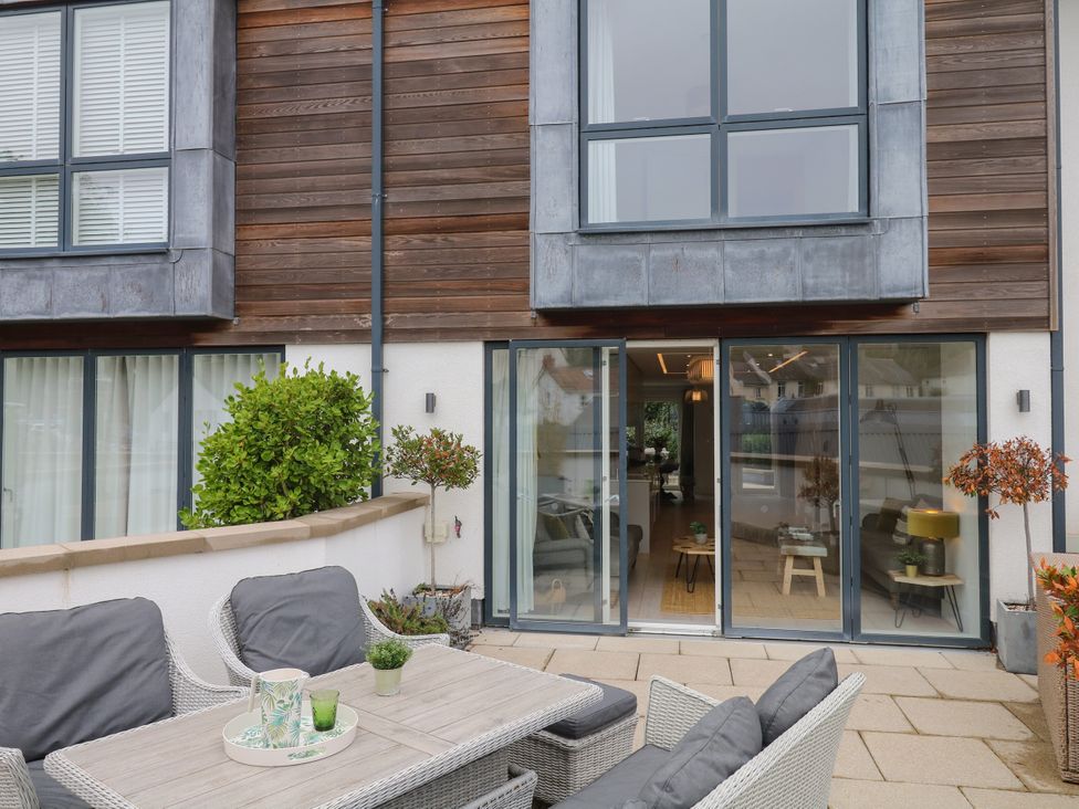 A patio with outdoor furniture and plants at Beachstone in Salcombe