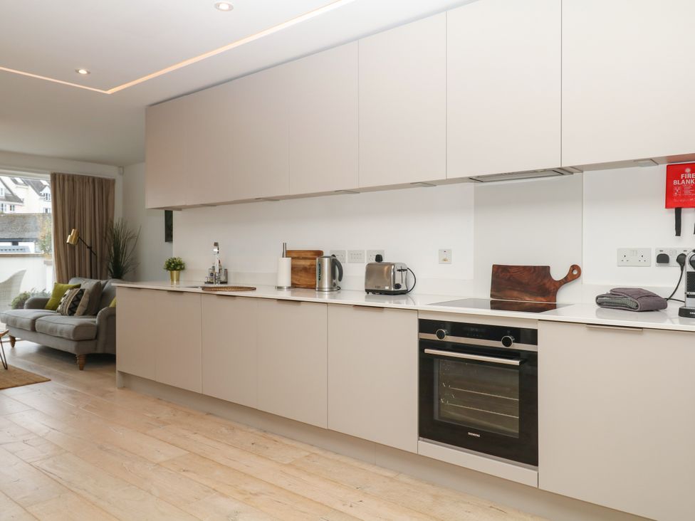 A kitchen with cabinets and appliances at Beachstone in Salcombe