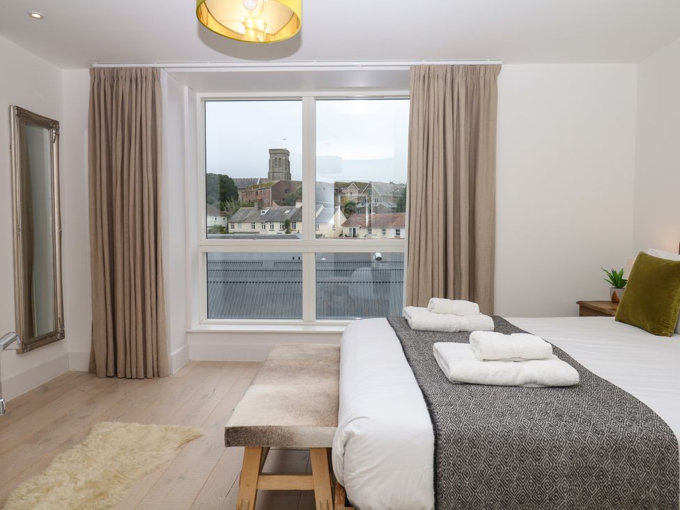 A bedroom with a bed and window at Beachstone in Salcombe