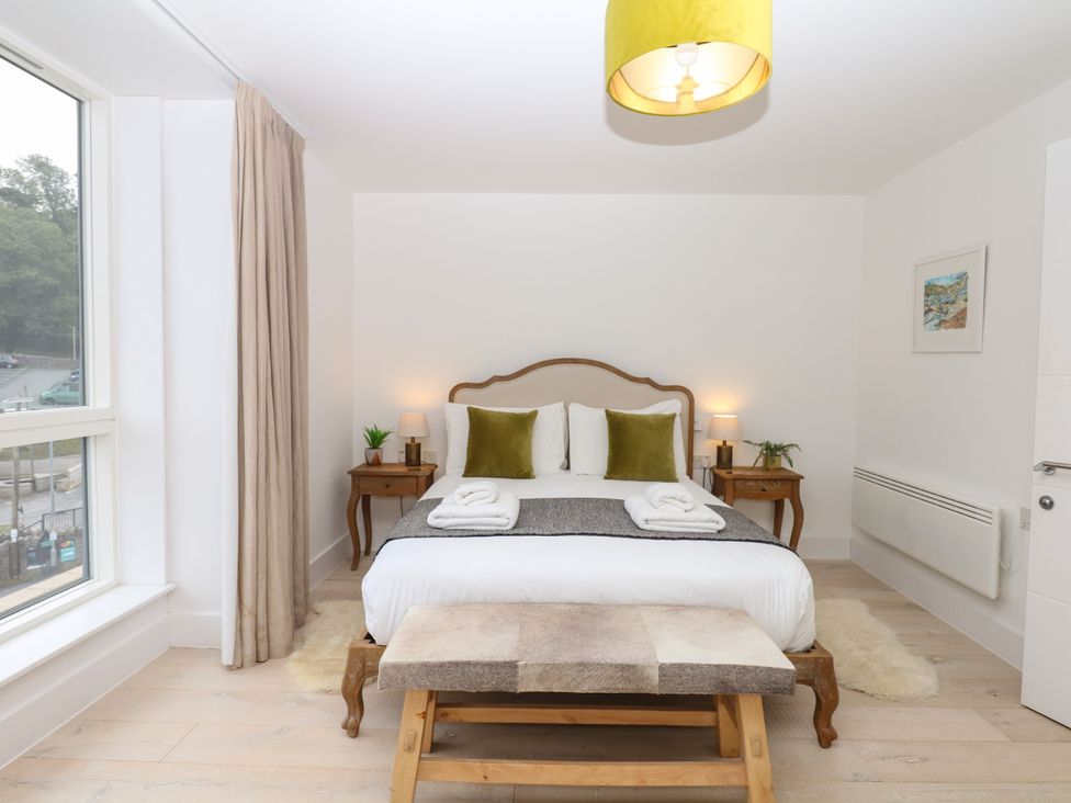 A bedroom with a bed and nightstand at Beachstone in Salcombe