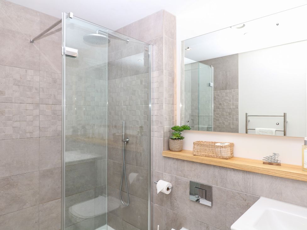 A bathroom with a shower and sink at Beachstone in Salcombe