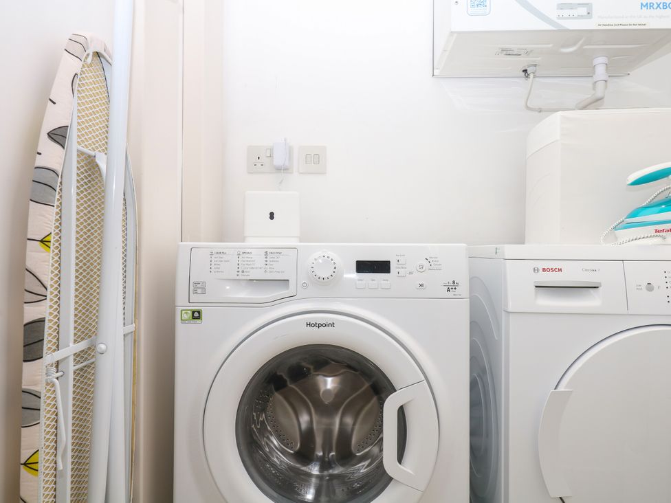 A laundry room with a washing machine and tumble dryer at Beachstone in Salcombe