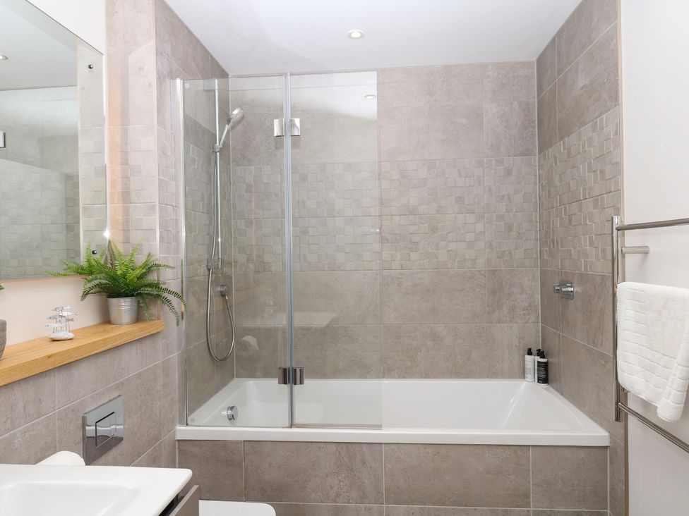 A bathroom with a shower and bathtub at Beachstone in Salcombe