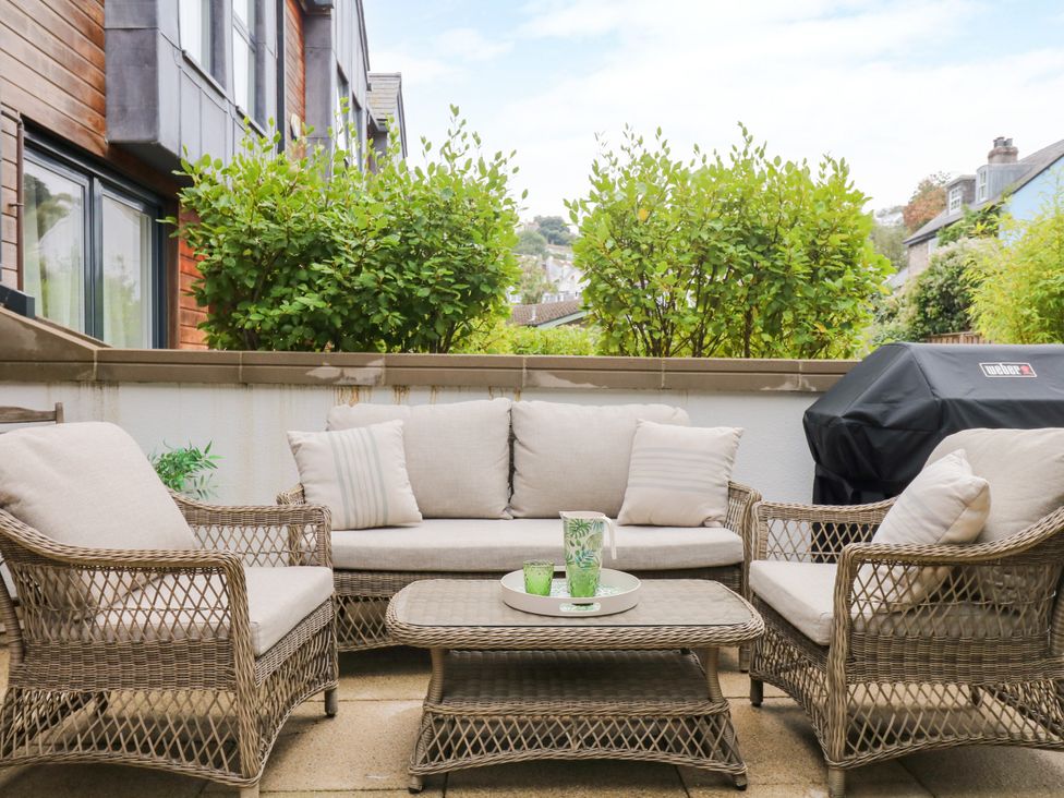 An outdoor seating area with a couch and coffee table at Beachstone in Salcombe