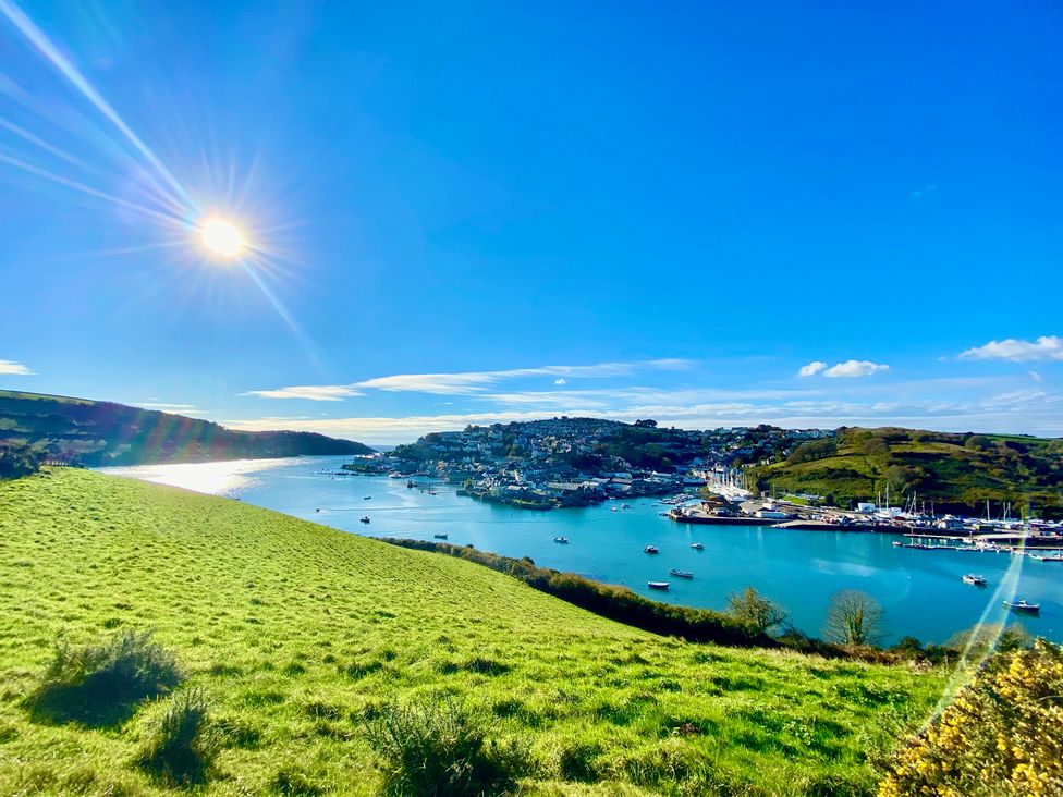 A view of the water and boats with hills and sunlight at Beachstone in Salcombe