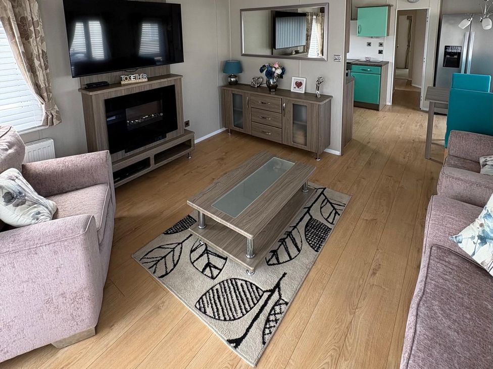 A living room with a television and coffee table at Lyons Robin Hood in Rhyl