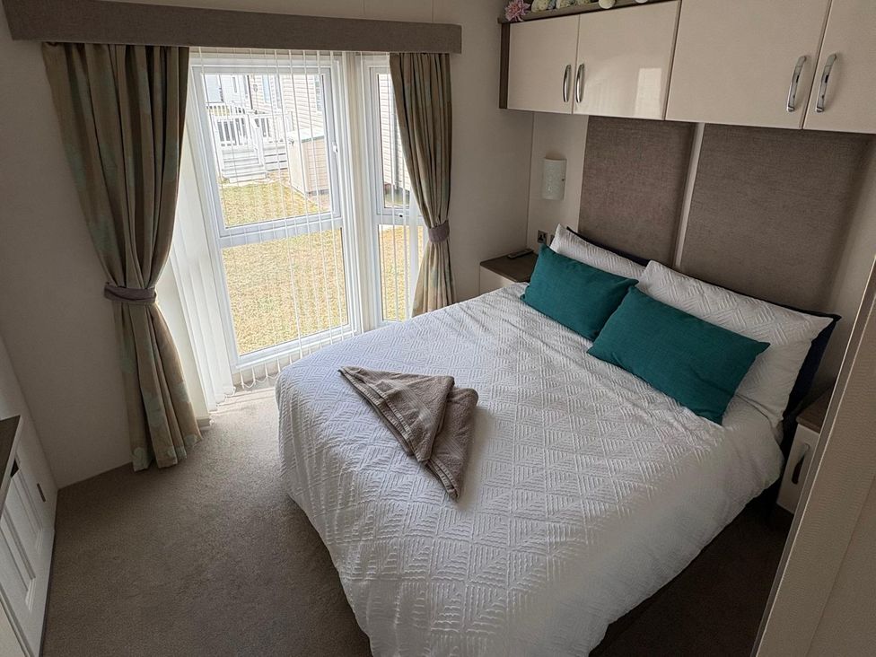 A bedroom with a bed and curtains at Lyons Robin Hood in Rhyl