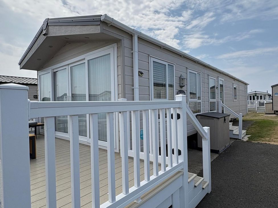 A mobile home with a deck and steps at Lyons Robin Hood in Rhyl