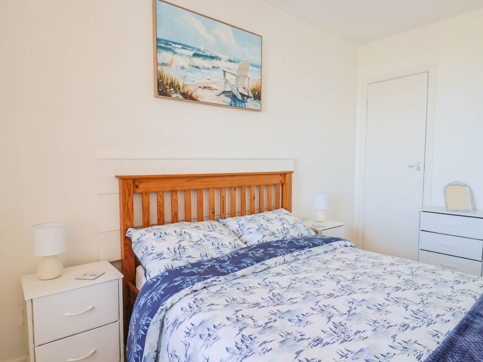 A bedroom with a bed and two bedside tables at 16 Old Shipyard Centre in West Bay