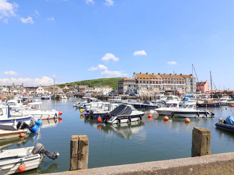 A harbor with boats and buildings at 16 Old Shipyard Centre in West Bay
