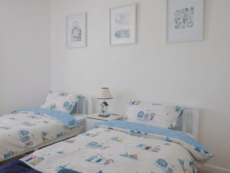 A bedroom with two beds and wall art at 16 Old Shipyard Centre, West Bay