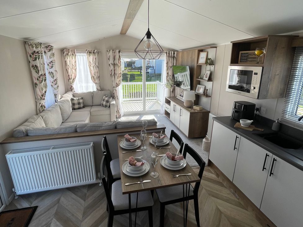 A living room with a sofa, table, and chairs at Unity Beach in Burnham-on-Sea