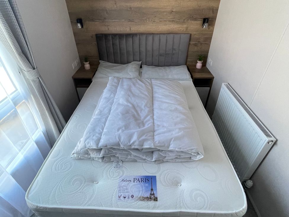 A bedroom with a bed and bedside table at Unity Beach in Burnham-on-Sea
