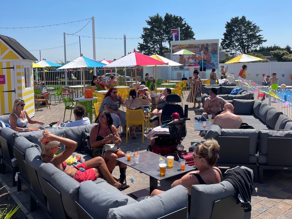 An outdoor area with couches and tables at Unity Beach in Burnham-on-Sea