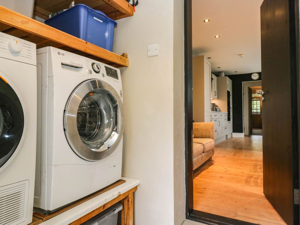 A utility room with a washing machine and tumble dryer at Briargarth in Keswick