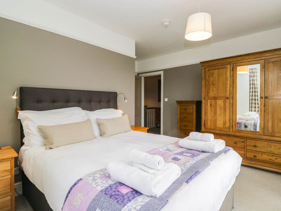 A bedroom with a bed and wardrobe at Briargarth in Keswick