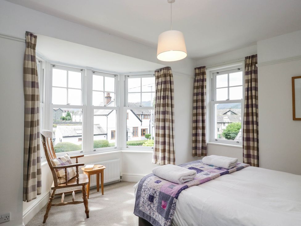 A bedroom with a bed and armchair at Briargarth in Keswick