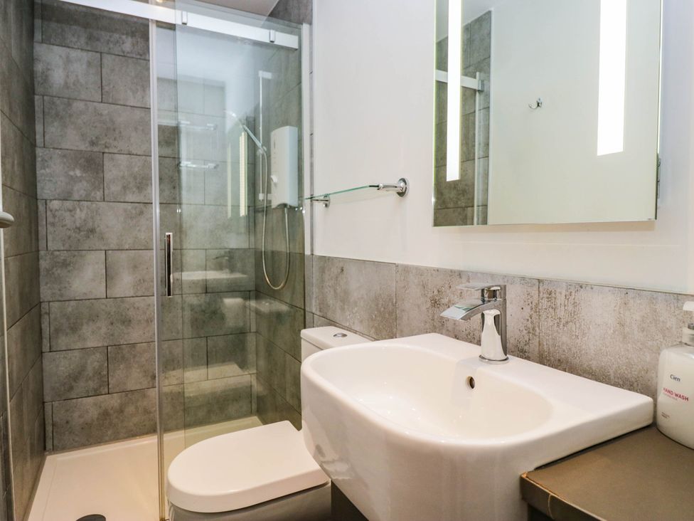 A bathroom with a shower, toilet, and sink at Briargarth in Keswick