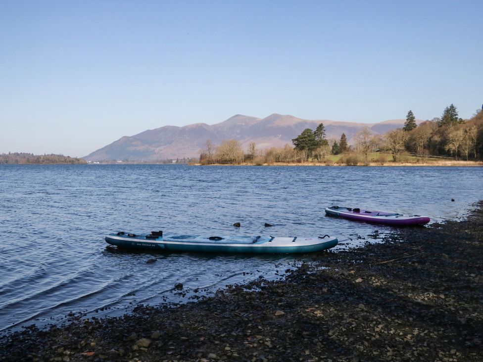 Two kayaks on the shore of a lake with mountains in the background at Briargarth in Keswick
