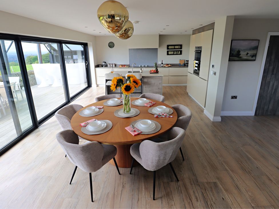 A dining room with a round table and flower vase at Parrott's Nest in Hyde