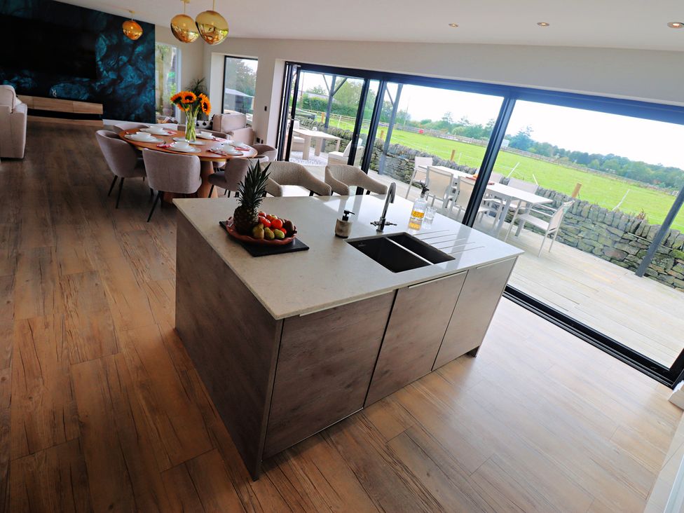 A kitchen with a dining area and an island at Parrott's Nest in Hyde