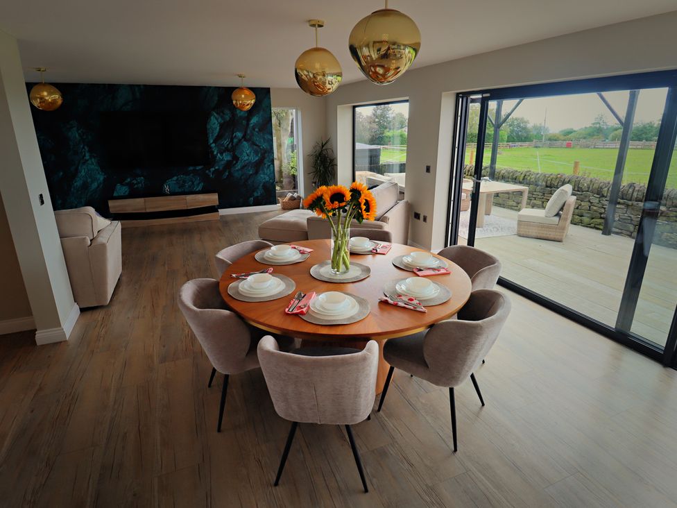 A dining room with a round table and chairs at Parrott's Nest in Hyde