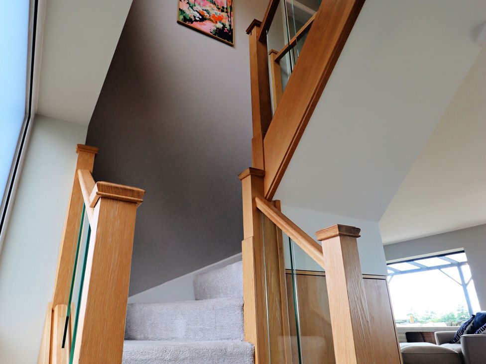 A staircase with wooden handrails and a painting at Parrott's Nest in Hyde