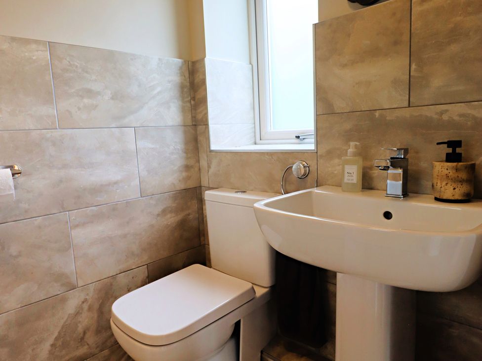 A bathroom with a toilet and sink at Parrott's Nest in Hyde
