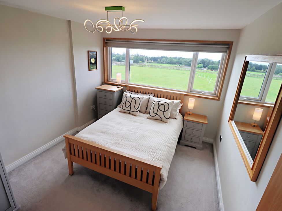 A bedroom with a bed and bedside tables at Parrott's Nest in Hyde