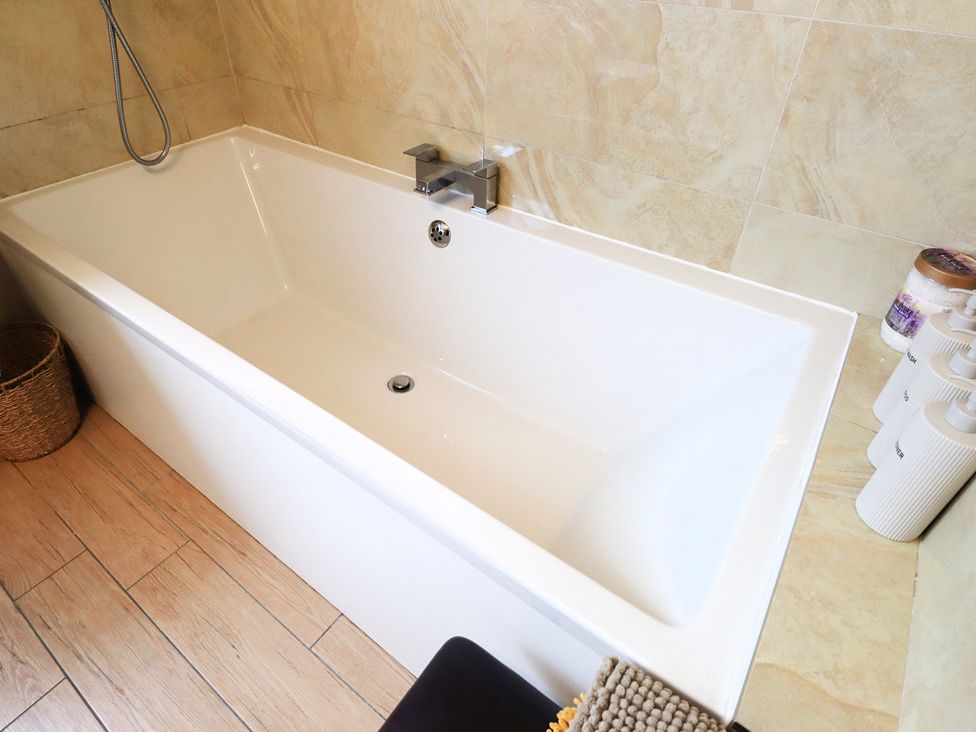 A bathroom with a bathtub and bottles at Parrott's Nest in Hyde