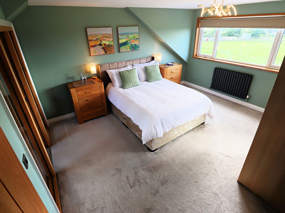 A bedroom with a bed and nightstand at Parrott's Nest in Hyde