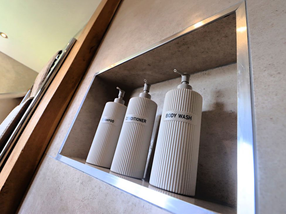 Three containers for shampoo, conditioner, and body wash at Parrott's Nest in Hyde