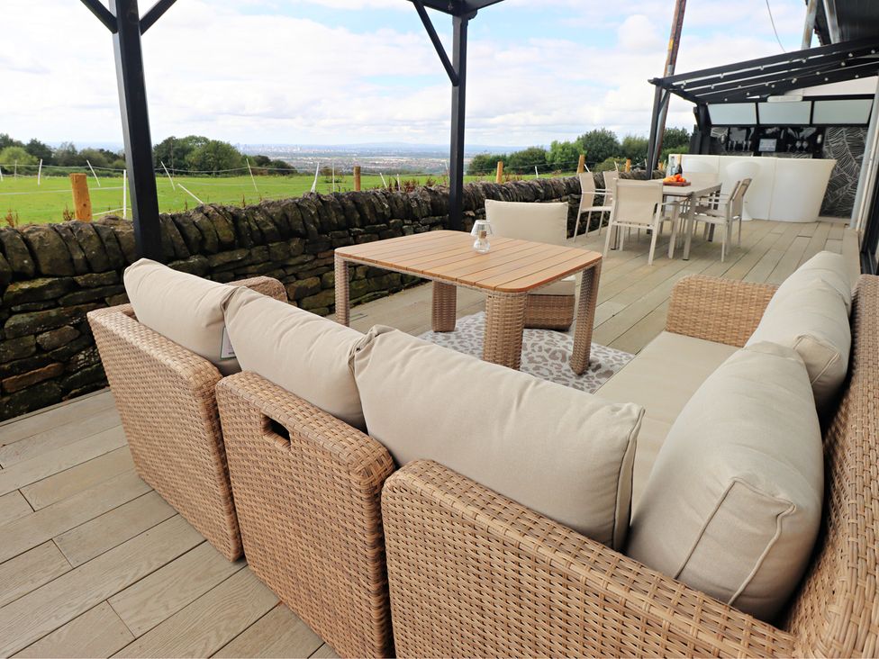 An outdoor patio with seating and a table at Parrott's Nest in Hyde