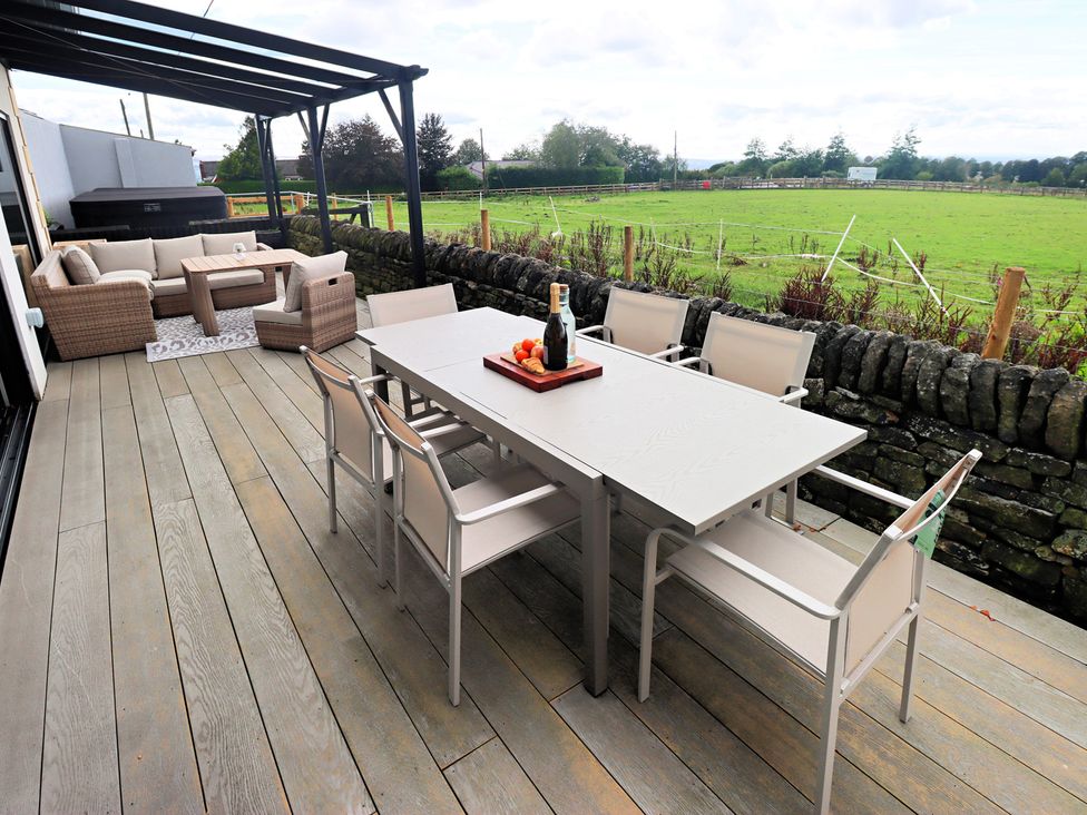 An outdoor patio with a table and seating at Parrott's Nest in Hyde
