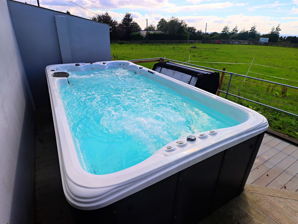 A hot tub with water in an outdoor area at Parrott's Nest in Hyde