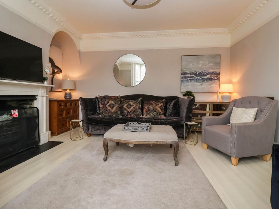 A living room with a sofa and fireplace at Cadogan House Easingwold