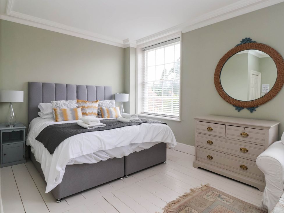 A bedroom with a bed, bedside table and dresser at Cadogan House Easingwold