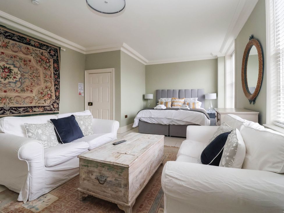 A bedroom with a bed and sitting area at Cadogan House in Easingwold