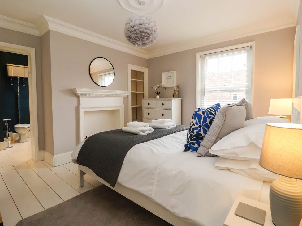 A bedroom with a bed and dresser at Cadogan House in Easingwold