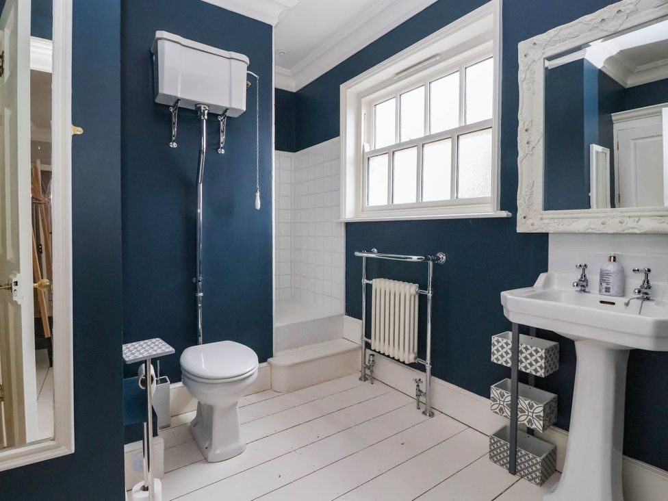 A bathroom with a toilet, sink, shower, and radiator at Cadogan House in Easingwold