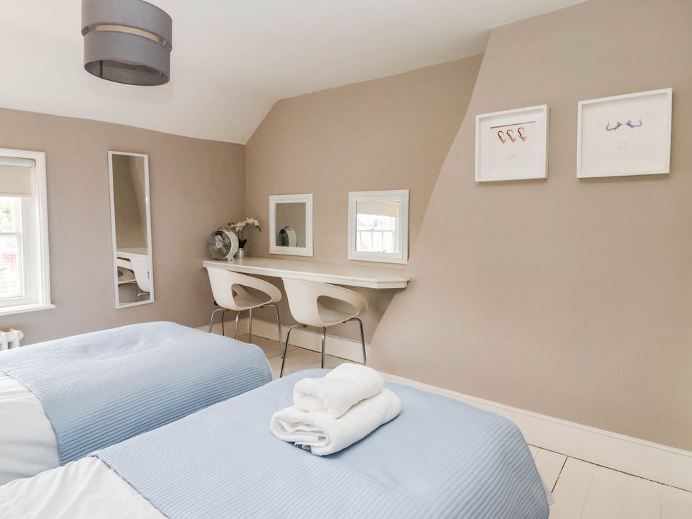 A bedroom with two beds and a table at Cadogan House Easingwold